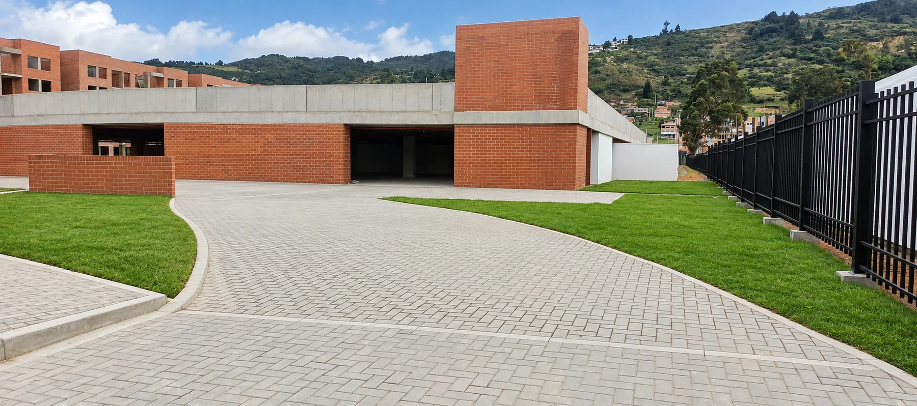 Acceso adoquinado con zonas verdes del portafolio de N@RMAK